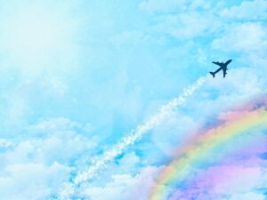 虹のかかる青空を飛ぶ飛行機